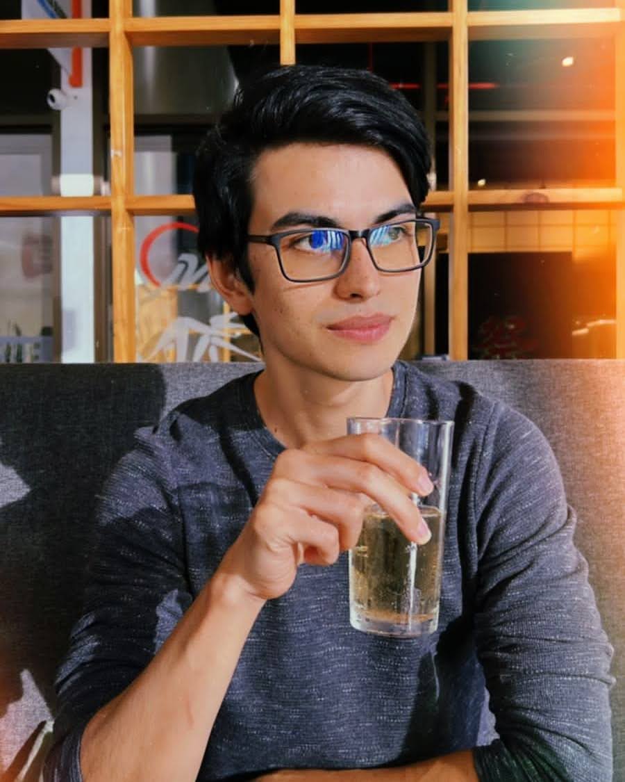 Daniel Cornejo smiling in a gray shirt and glasses